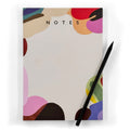 Assemblage A5 notepad with colourful abstract design and black pencil