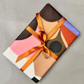 Gift wrapped in Assemblage paper with orange satin ribbon