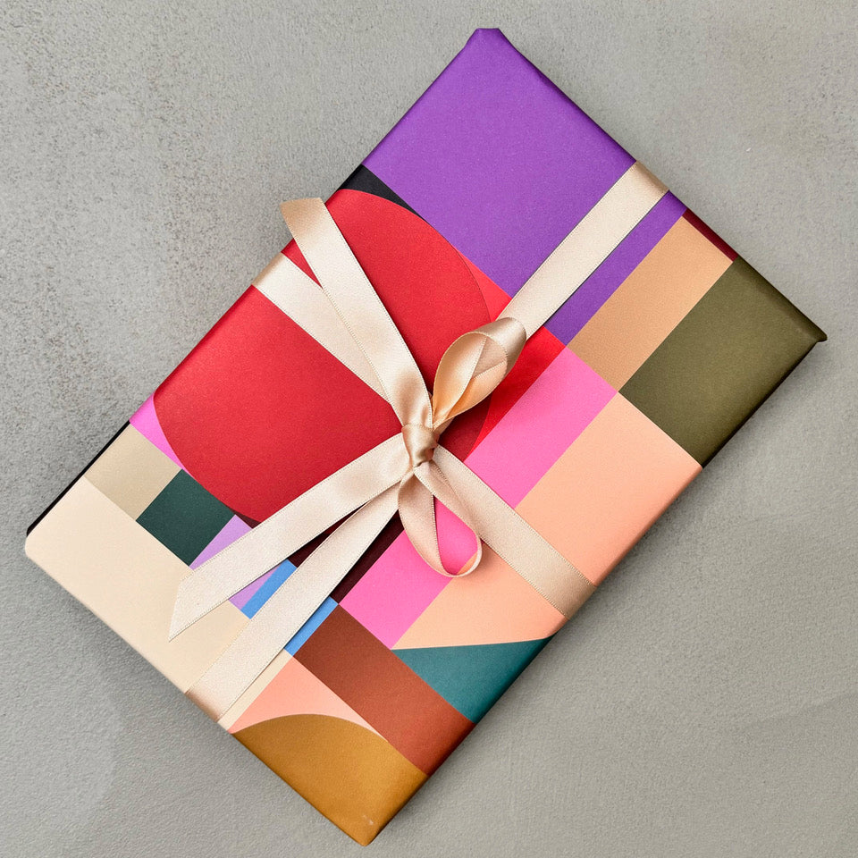 Wrapped gift in Broadcast wrapping paper with champagne ribbon