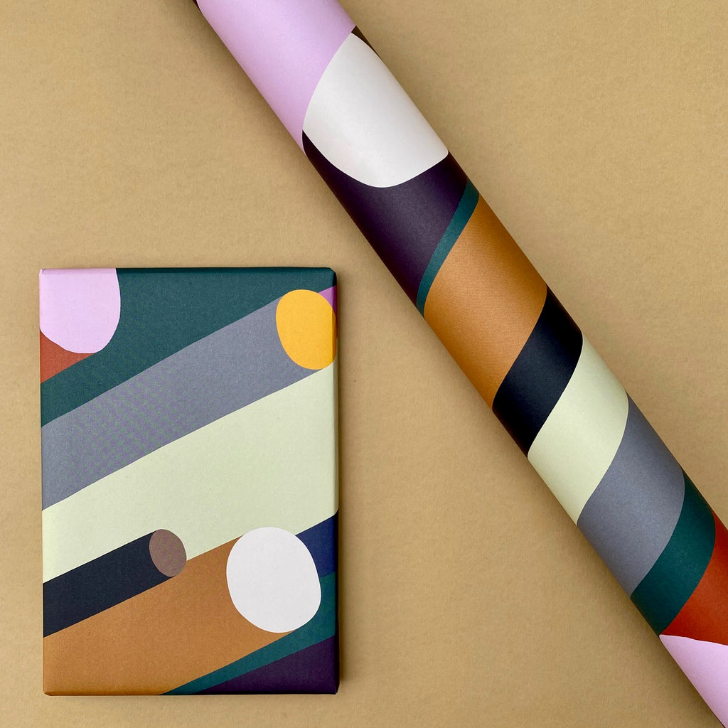 Cylinder wrapping paper shown as a wrapped gift alongside a roll of the design