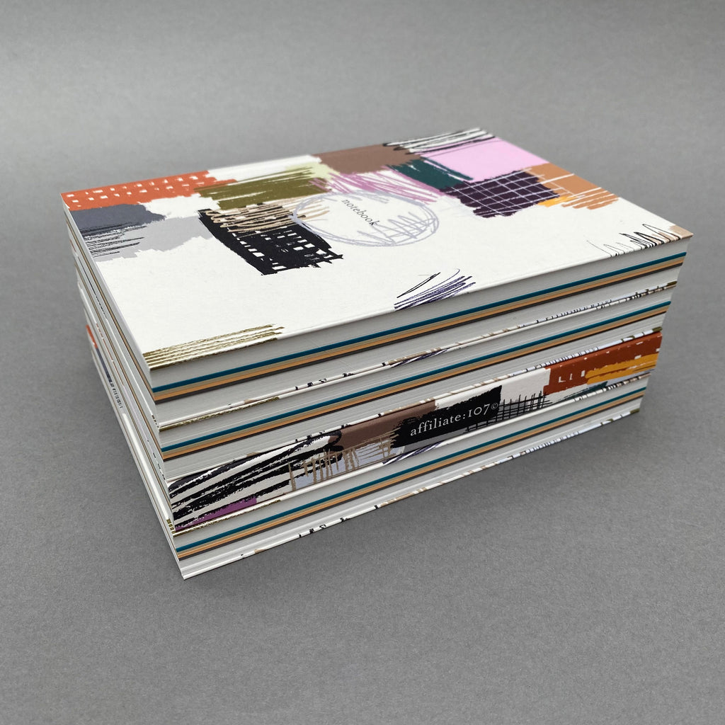 Stack of Etch Notebooks showing colourful page sections and extended covers