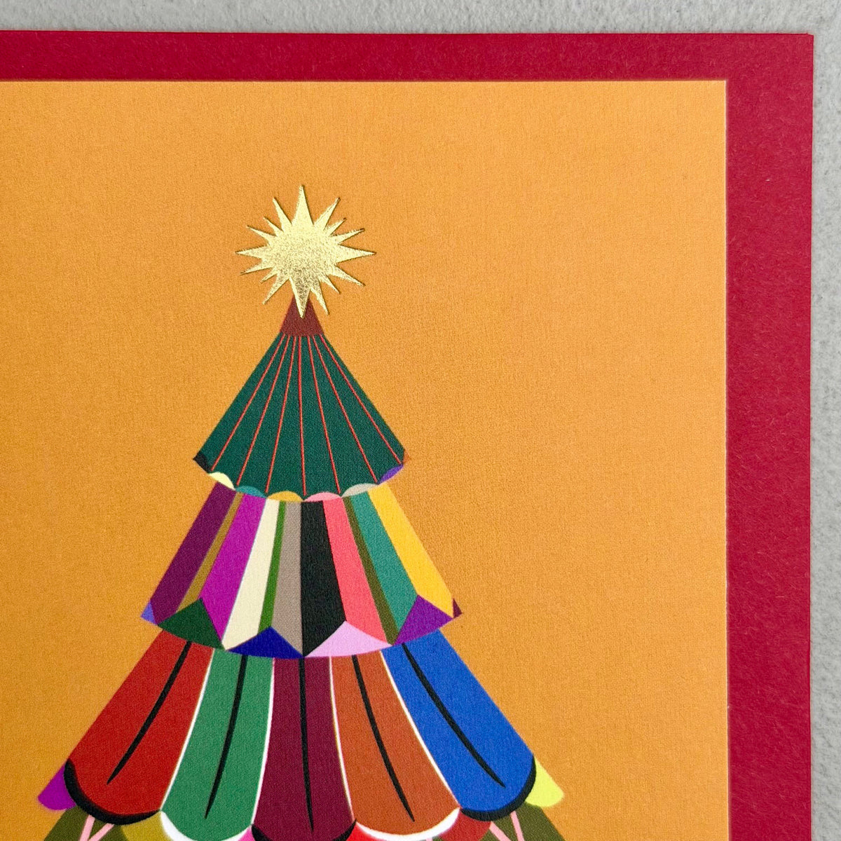Close-up of Festive Tree Season's Greetings card showing colourful layered tree and gold foil star