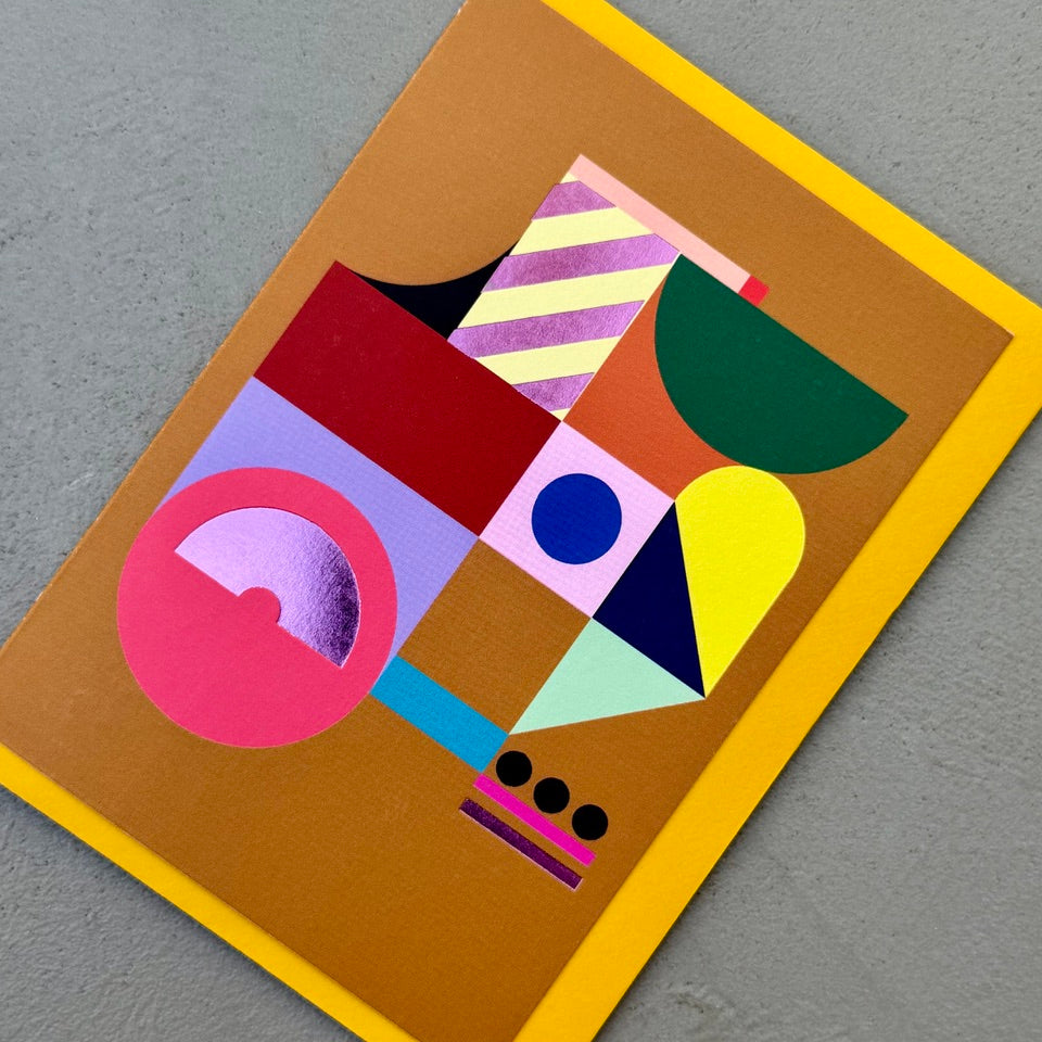 Angled view of the Geometric Abstract No.2 greeting card with a mustard yellow envelope, showcasing the abstract geometric artwork and purple foil finish.