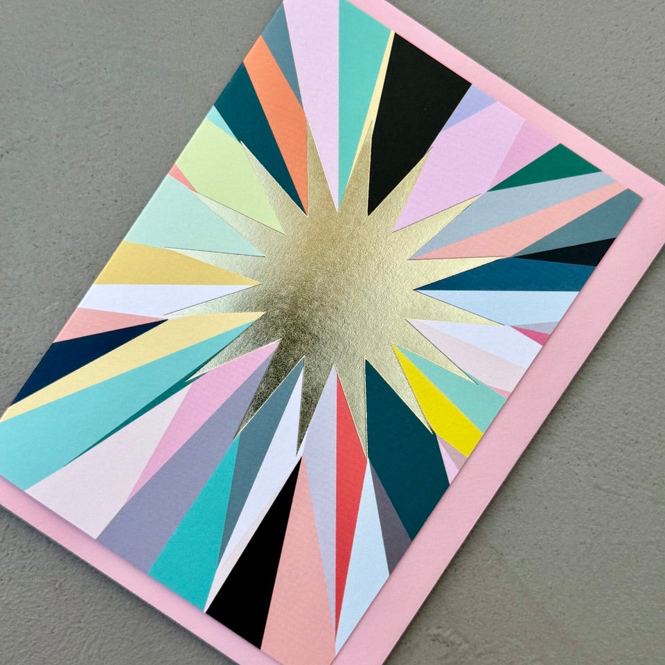Angled view of the Gold Foil Starburst Card on a pale pink envelope.
