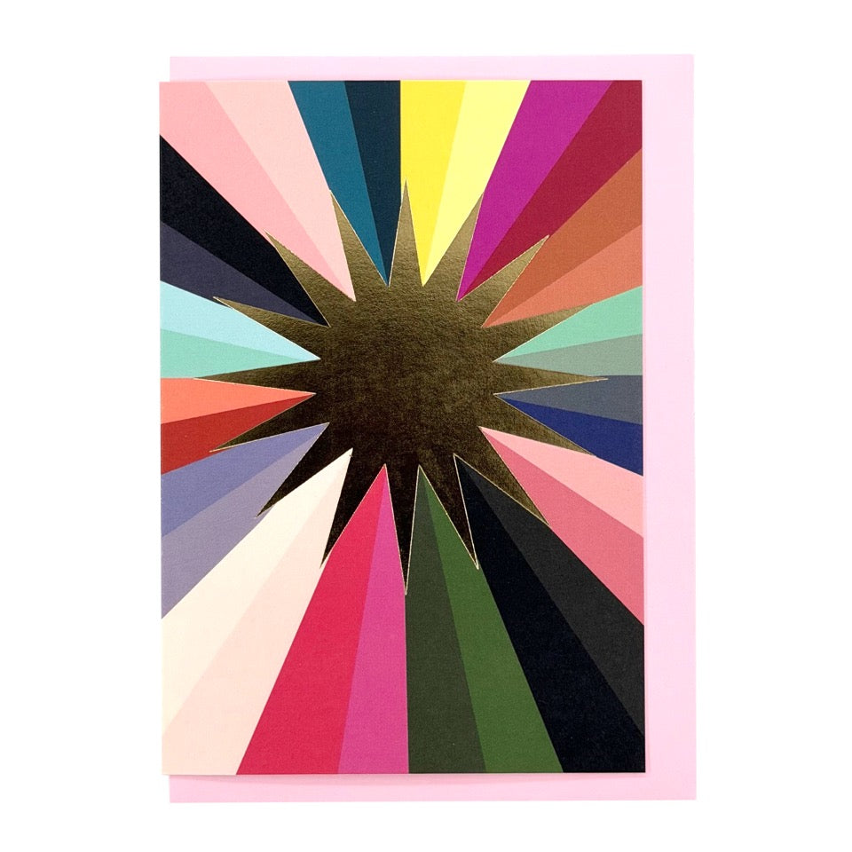 Greeting card featuring a gold foil sunburst with colourful radiating stripes on a pale pink envelope.