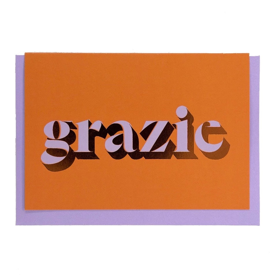 Orange Grazie card with lilac lettering and copper foil detail, shown with a lilac envelope.