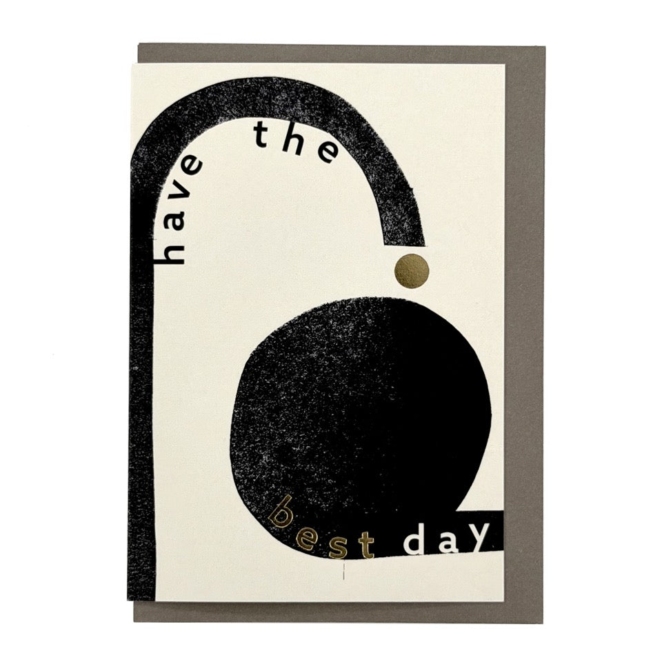 Modern typographic greeting card with bold black abstract shapes, gold foil details and the message "Have the Best Day", paired with a warm grey envelope.