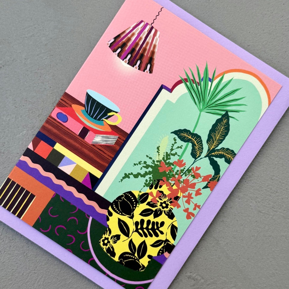 Angled view of the Home Sanctuary greeting card on a lilac envelope.