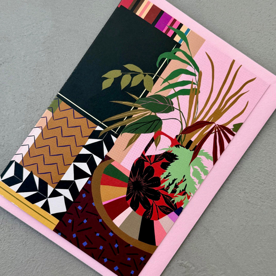 Angled view of the Houseplant Interior greeting card on a pink envelope.
