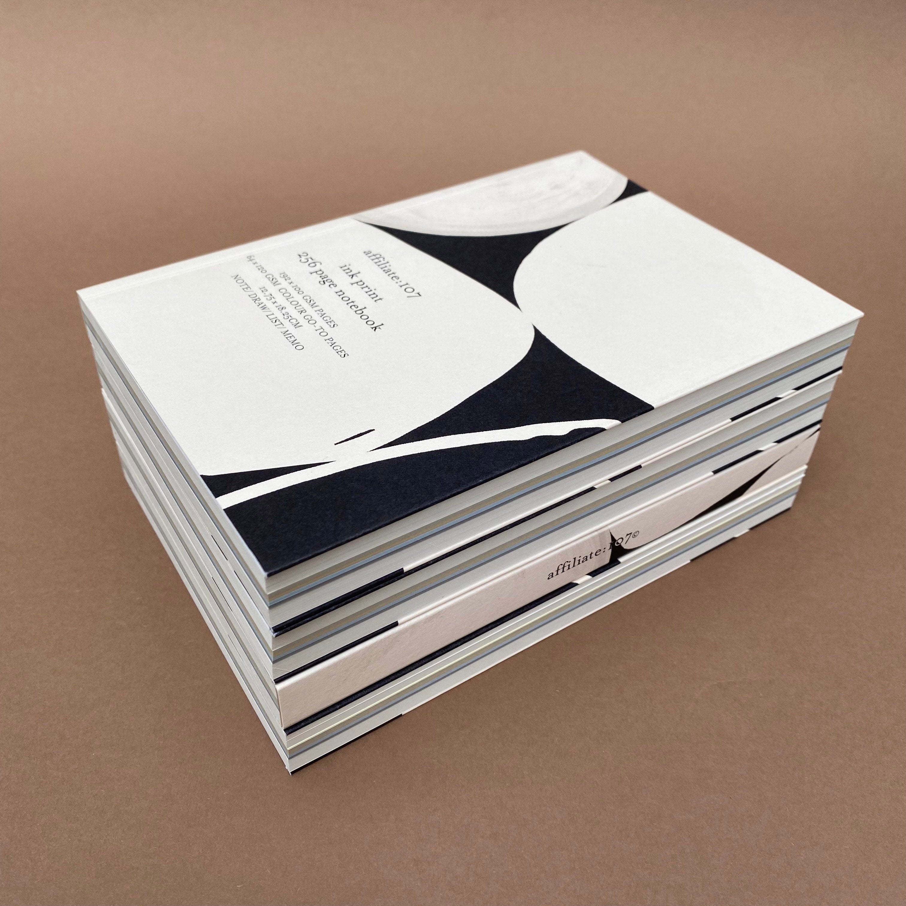 Stack of Ink Notebooks showing coloured page sections and extended covers