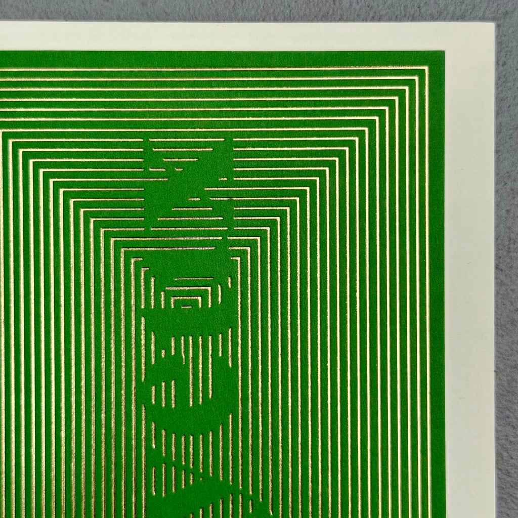Close-up of Joyeux Christmas card showing intricate gold foil lines with gaps forming the word Joyeux
