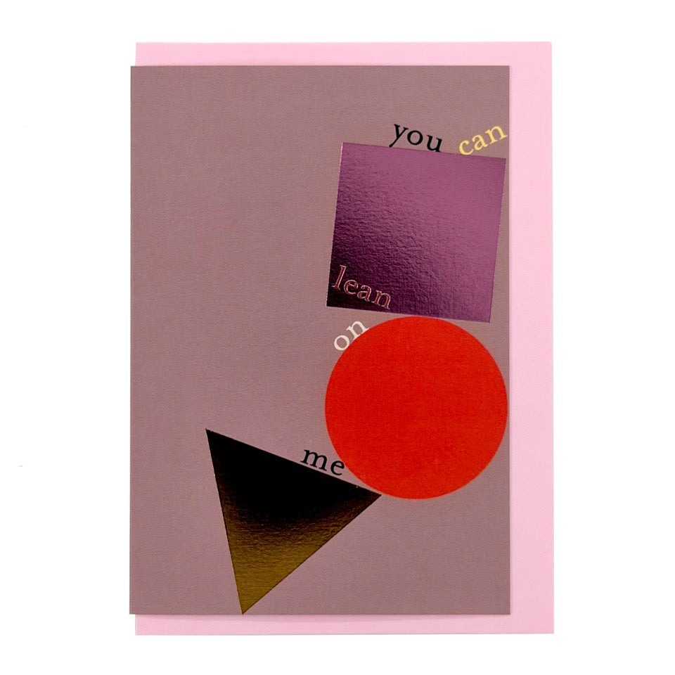 Modern greeting card featuring abstract geometric shapes with the message "you can lean on me", finished with metallic foil details and paired with a soft pink envelope.