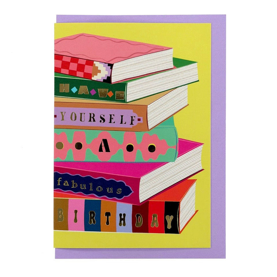 Have Yourself a Fabulous Birthday card featuring a colourful stack of illustrated books, shown with a lavender envelope.
