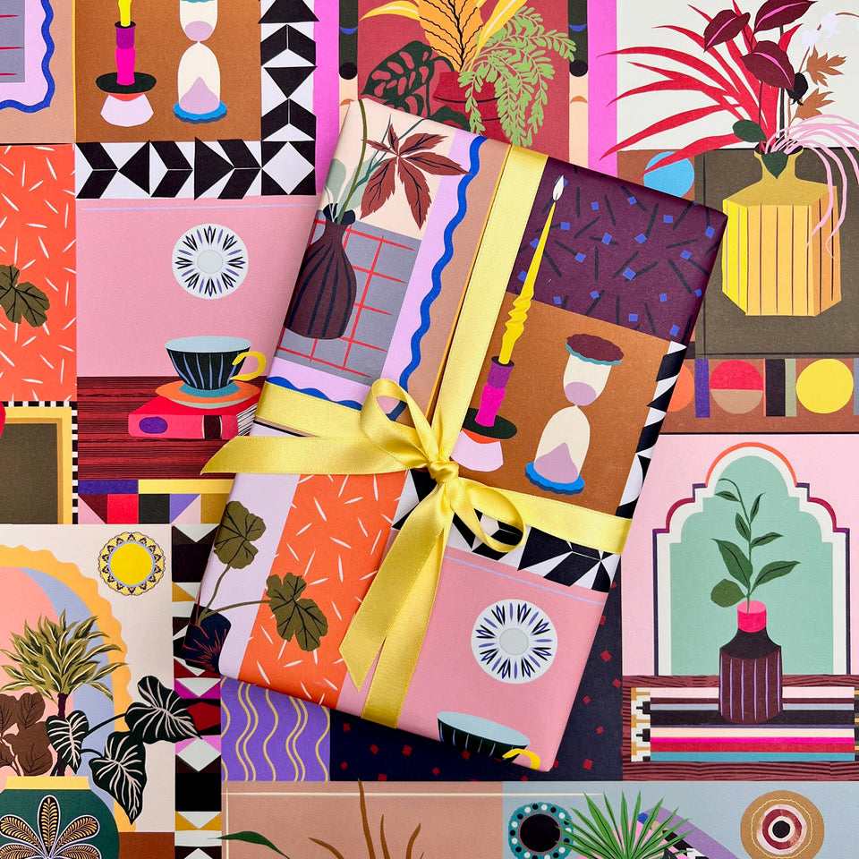 Lifestyle wrapping paper with wrapped gift styled against the colourful interior-inspired pattern