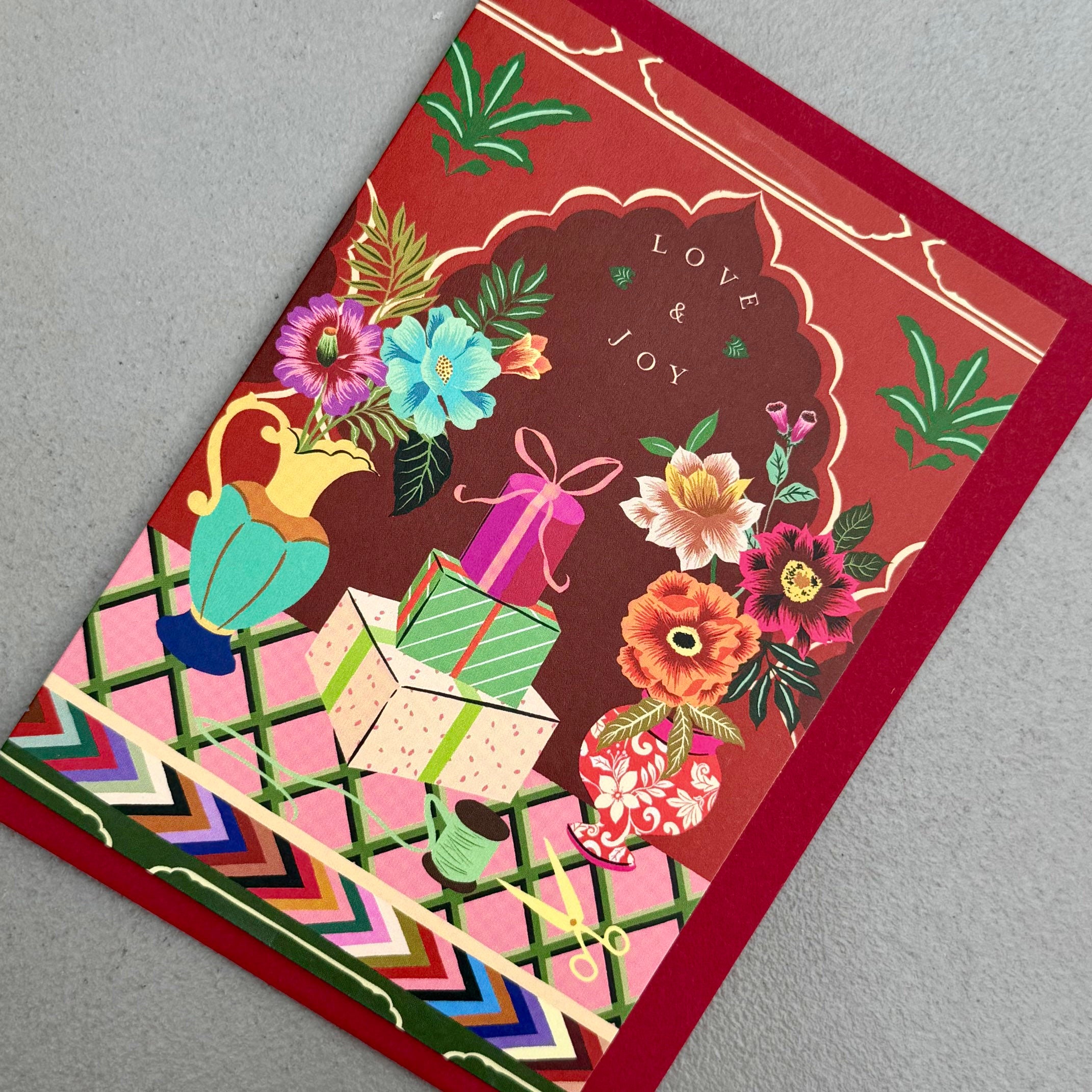 Angled view of Love & Joy Christmas card by PAVILION with red envelope