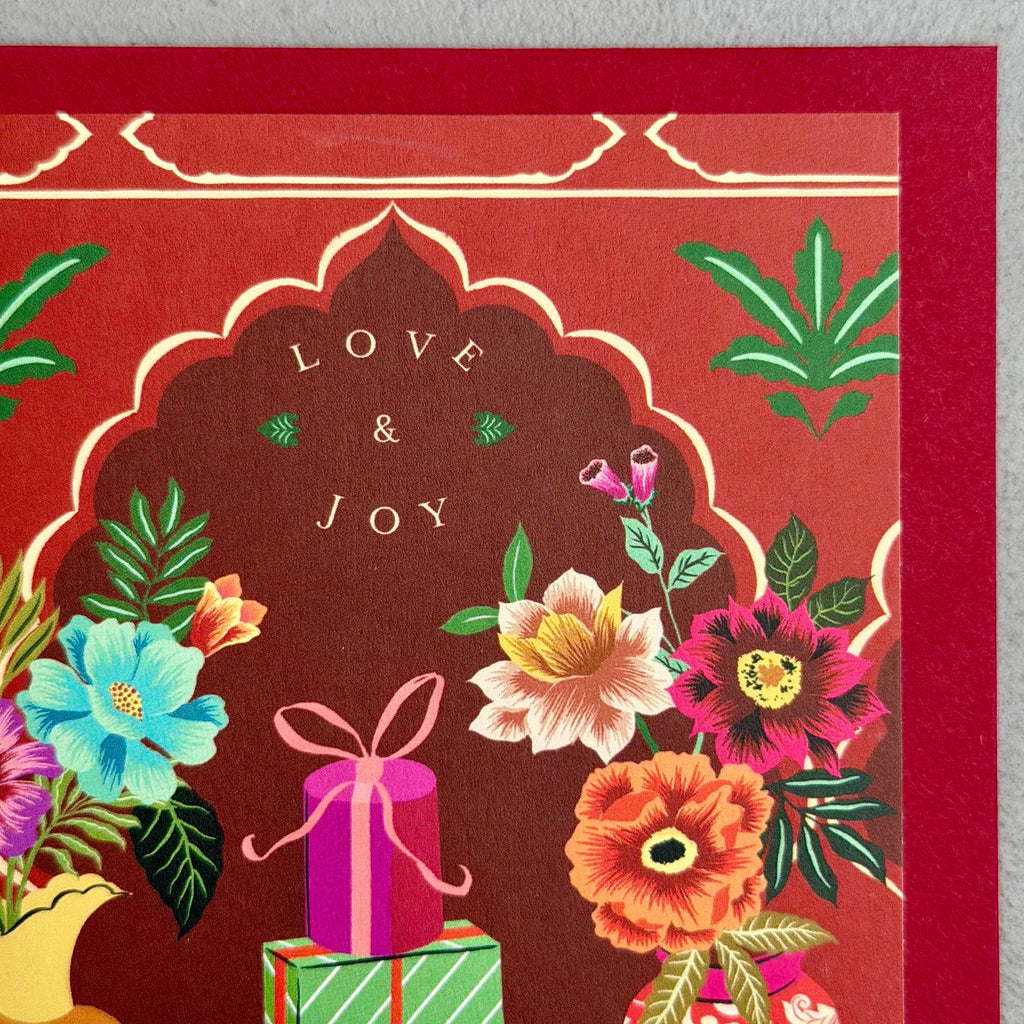 Close-up of Love & Joy Christmas card showing the floral detail, gifts and “Love & Joy” greeting

