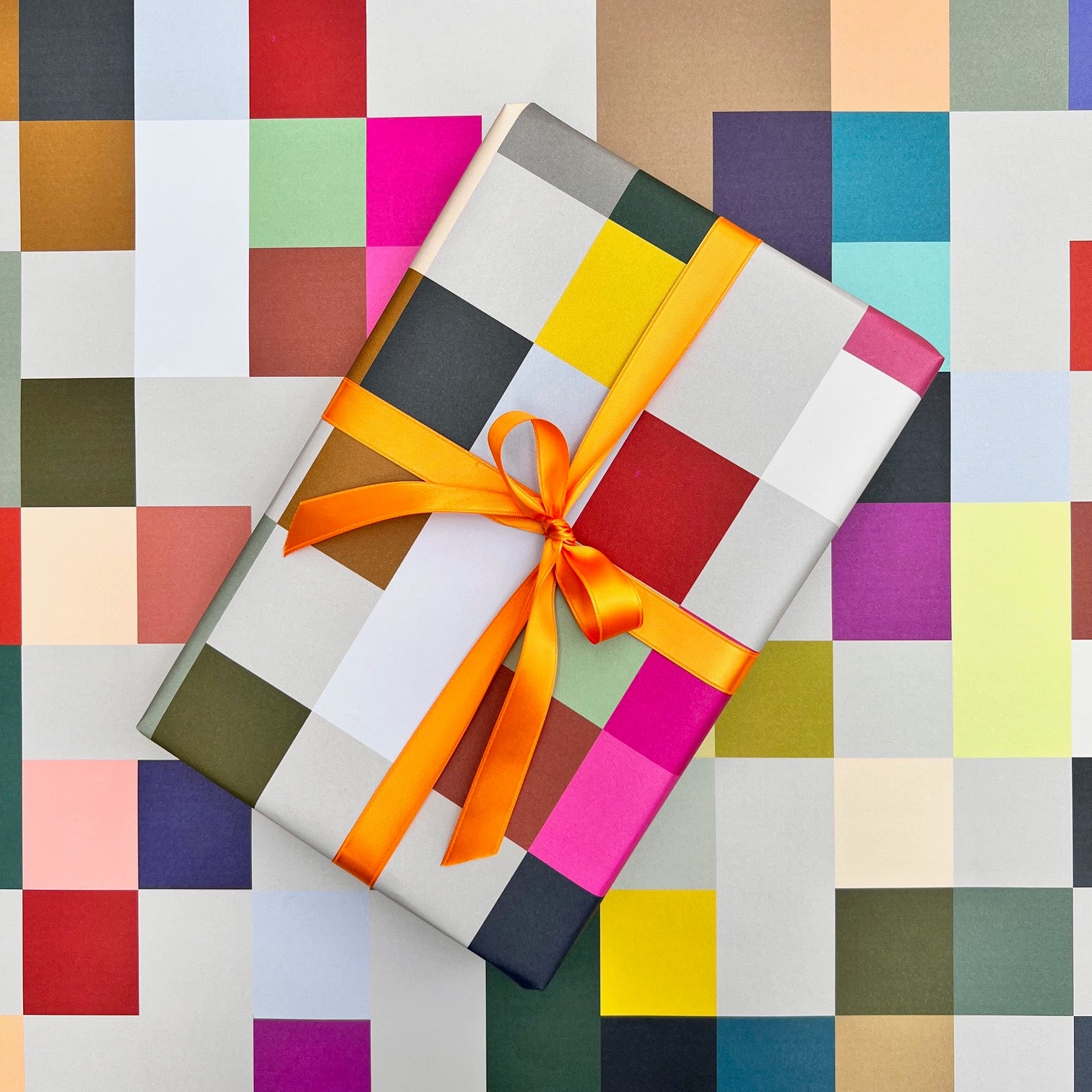Madras wrapping paper with wrapped gift styled against the colourful grid pattern