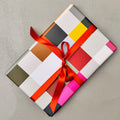 Wrapped gift in Madras wrapping paper with red ribbon