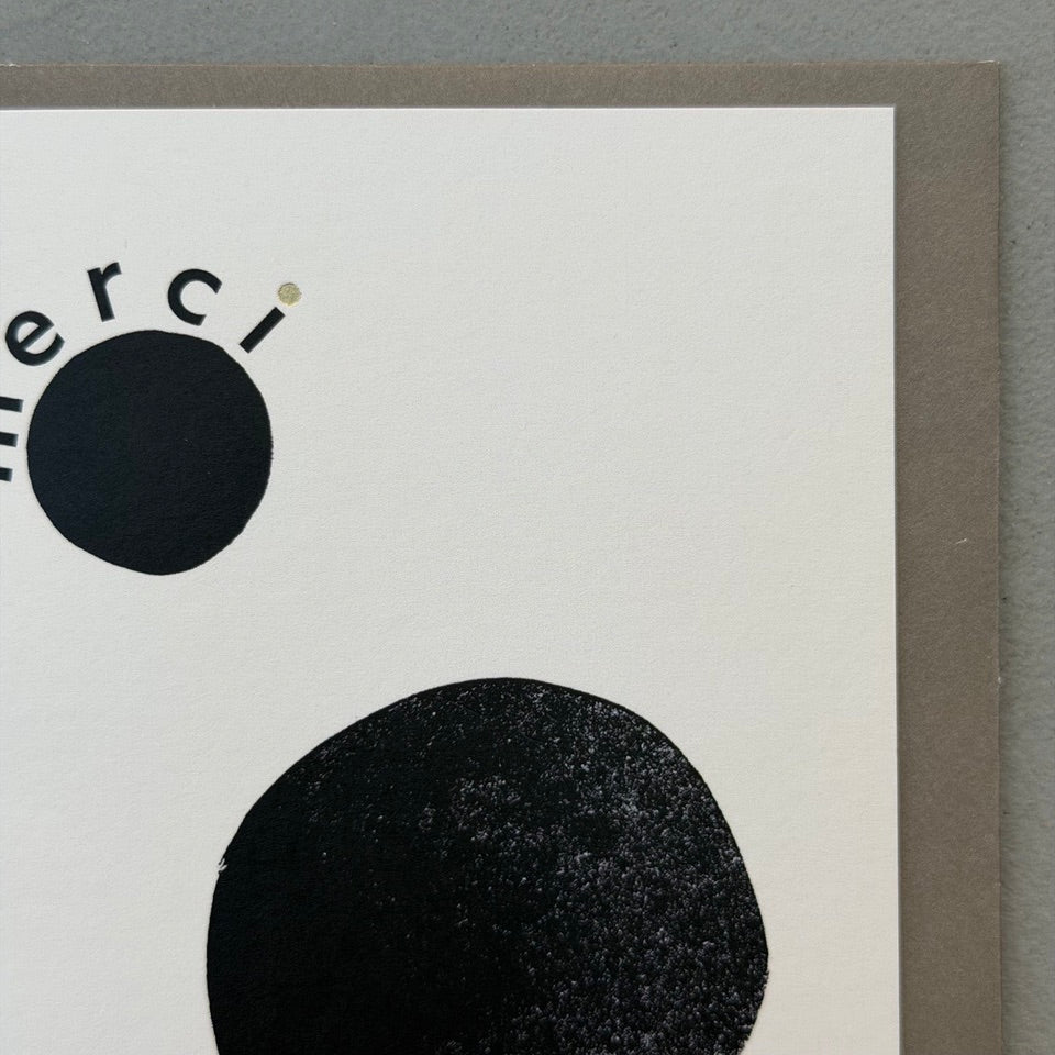 Close-up of the Merci Beaucoup card highlighting the textured black abstract shapes, gold foil lettering and clean contemporary design.