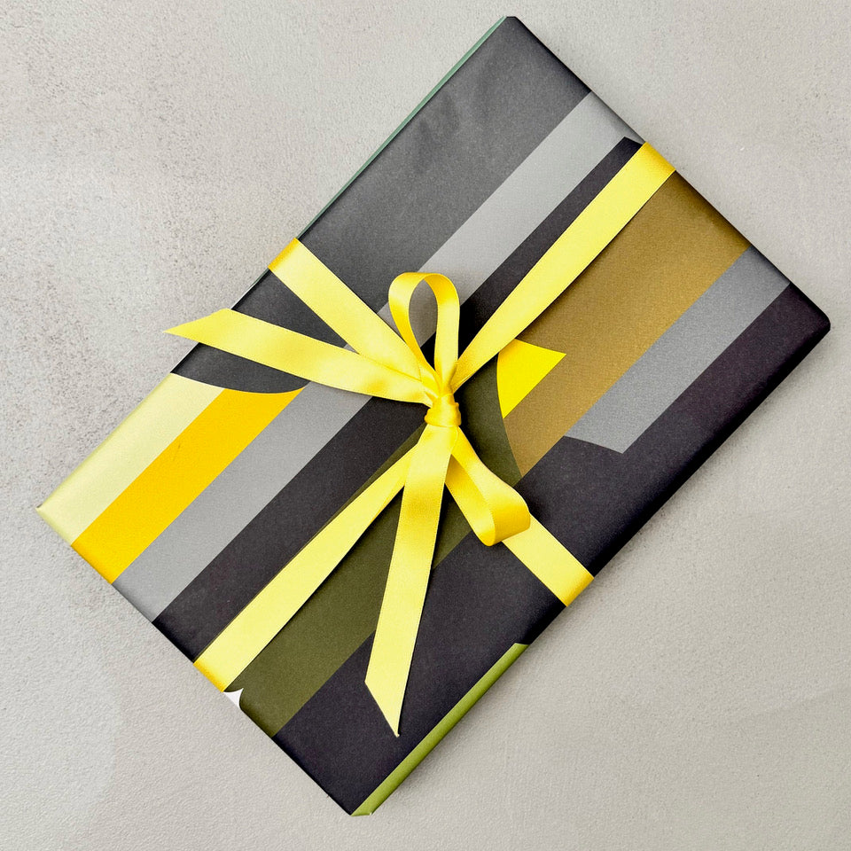 Wrapped gift in Monolith geometric wrapping paper with yellow ribbon