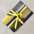 Wrapped gift in Monolith geometric wrapping paper with yellow ribbon