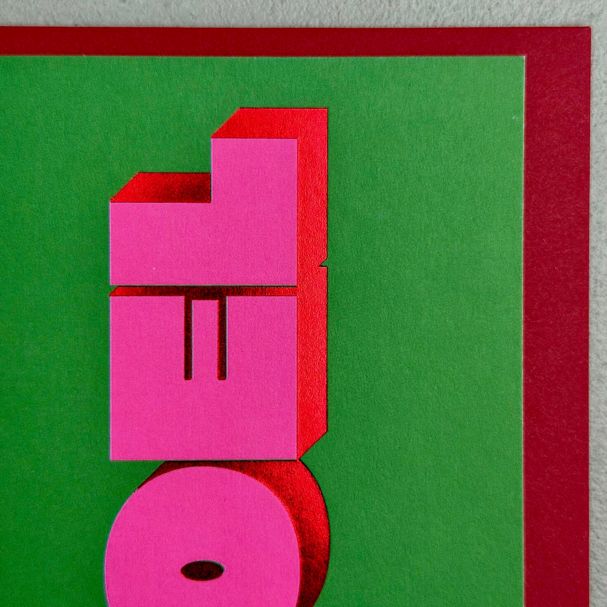 Close-up of Noel Christmas card showing bold pink 3D lettering and red foil details