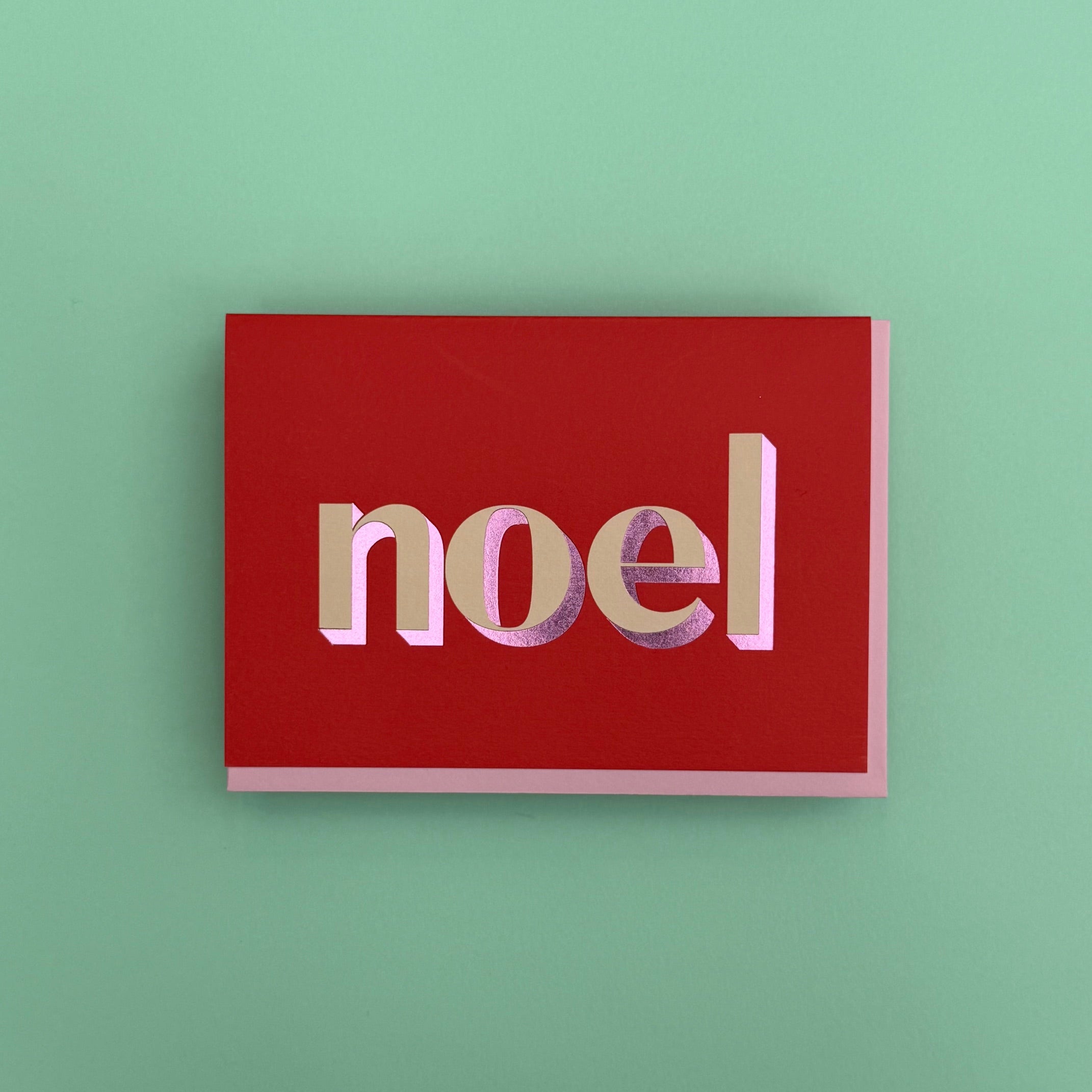 Noel Christmas card standing against a turquoise background