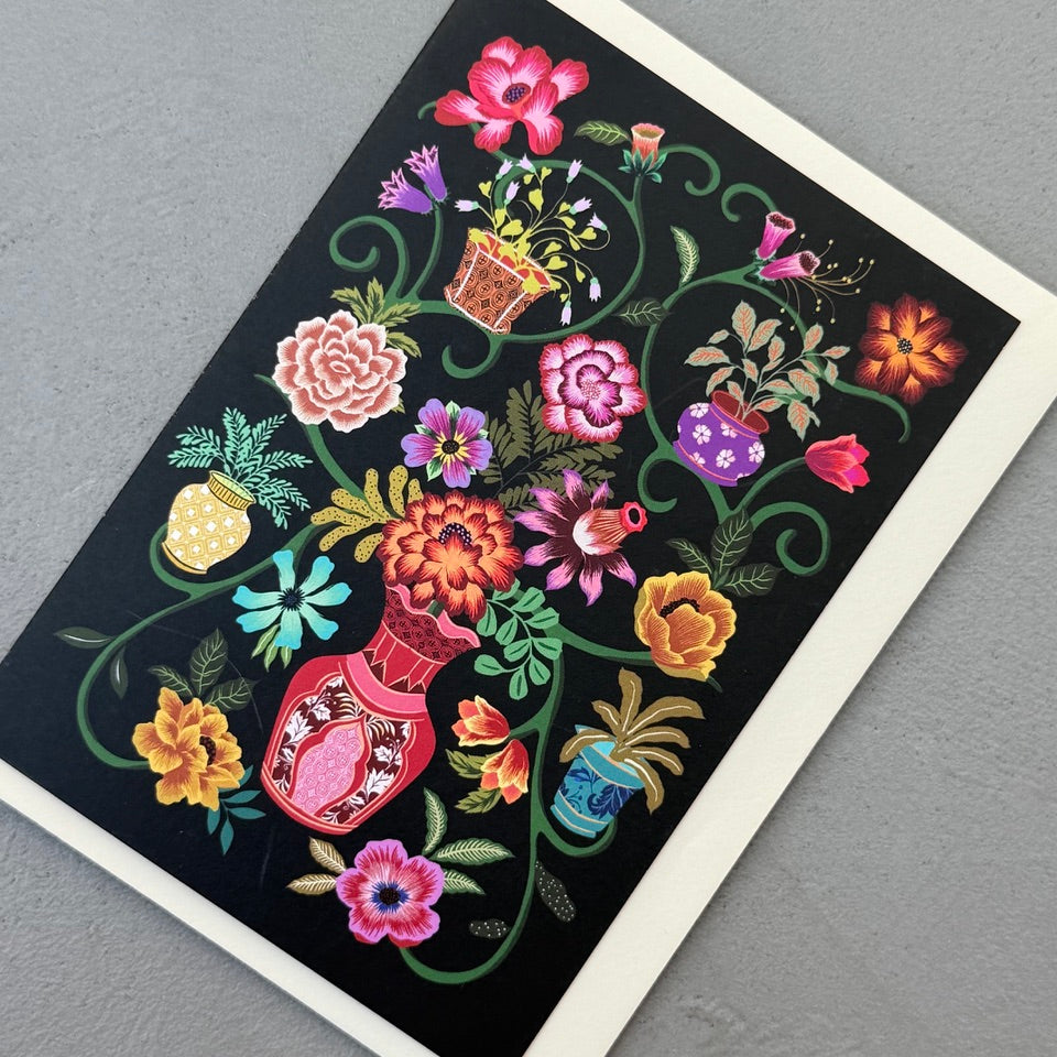 Angled view of the Painted Garden greeting card with a cream envelope, showcasing the richly illustrated floral artwork.
