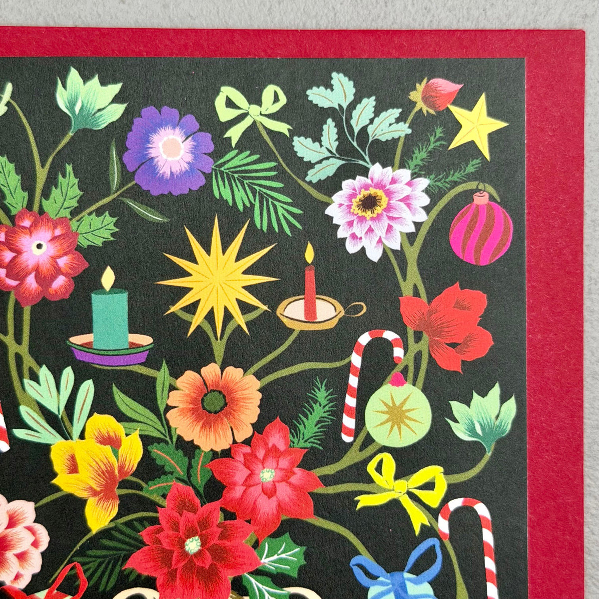Close-up of Painted Garden Christmas card showing flowers, candles, baubles and festive foliage
