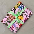 Wrapped gift in Painted Garden floral wrapping paper with green ribbon