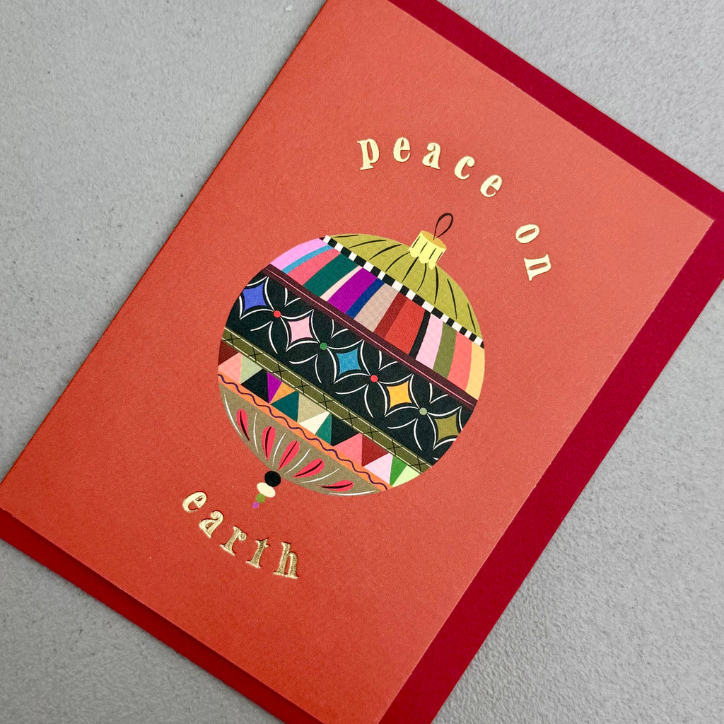 Angled view of Peace Bauble Christmas card by PAVILION with red envelope
