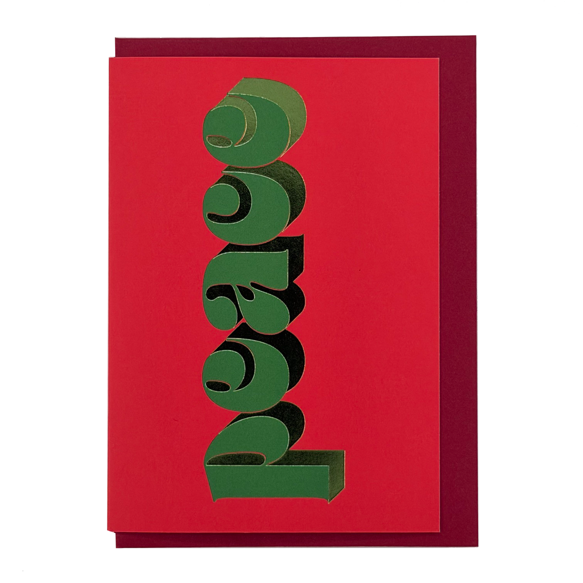 Front view of Peace Christmas card by PAVILION with green sculptural lettering on a vivid red background and red envelope