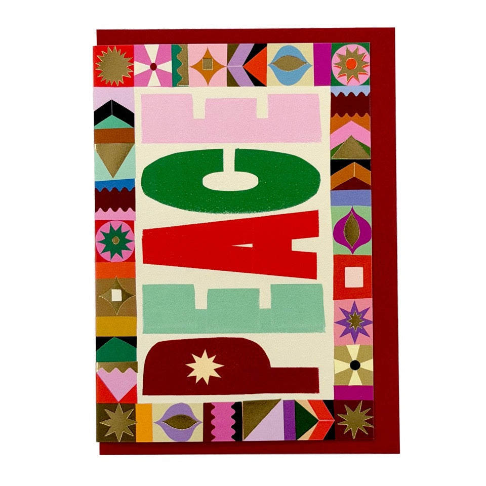 PEACE Christmas card by PAVILION with bold graphic lettering, decorative patterned border and red envelope
