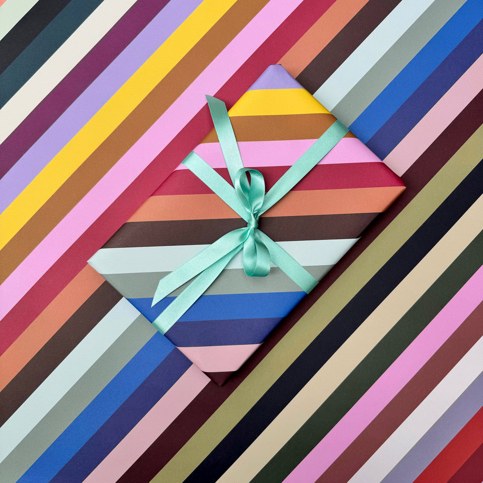 Radar wrapping paper with wrapped gift styled against the colourful striped pattern