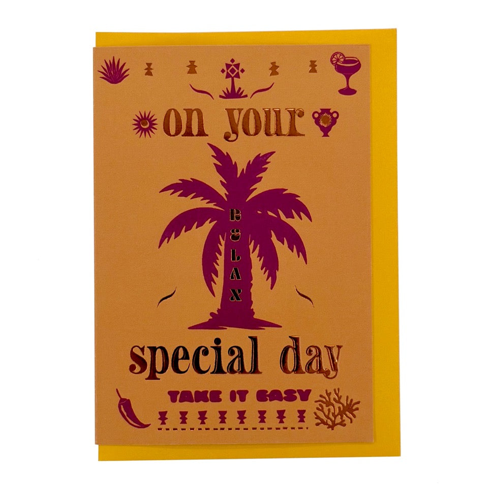 Foil-embellished greeting card featuring a vibrant pink palm tree with the message "Relax On Your Special Day", paired with a bright yellow envelope.