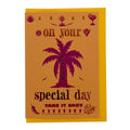 Foil-embellished greeting card featuring a vibrant pink palm tree with the message "Relax On Your Special Day", paired with a bright yellow envelope.