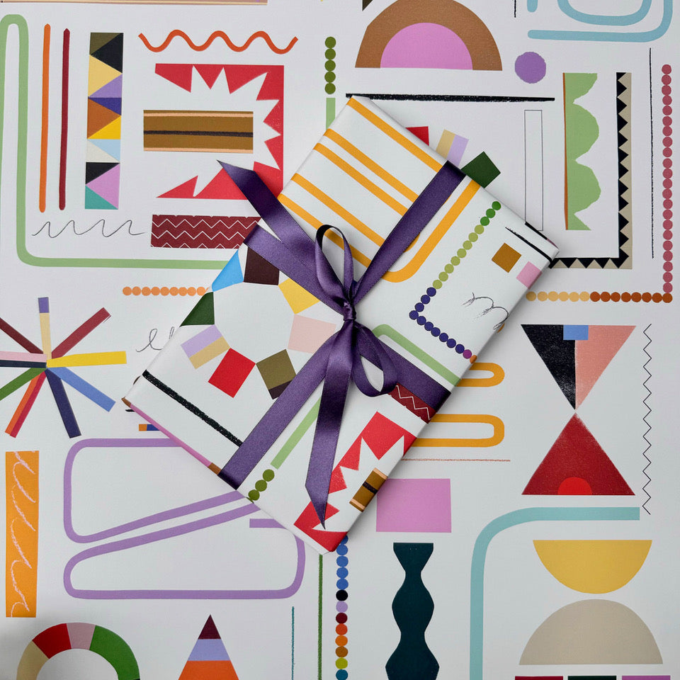 Scrapbook wrapping paper with wrapped gift styled against the graphic pattern