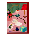 Season's Greetings card by PAVILION with illustrated festive desk scene, flowers, cocktail, lamp and red envelope
