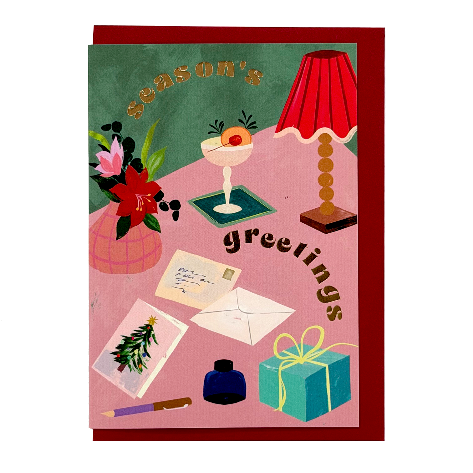 Season's Greetings card by PAVILION with illustrated festive desk scene, flowers, cocktail, lamp and red envelope