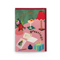 Season's Greetings Christmas card featuring a festive tabletop scene with gold foil lettering