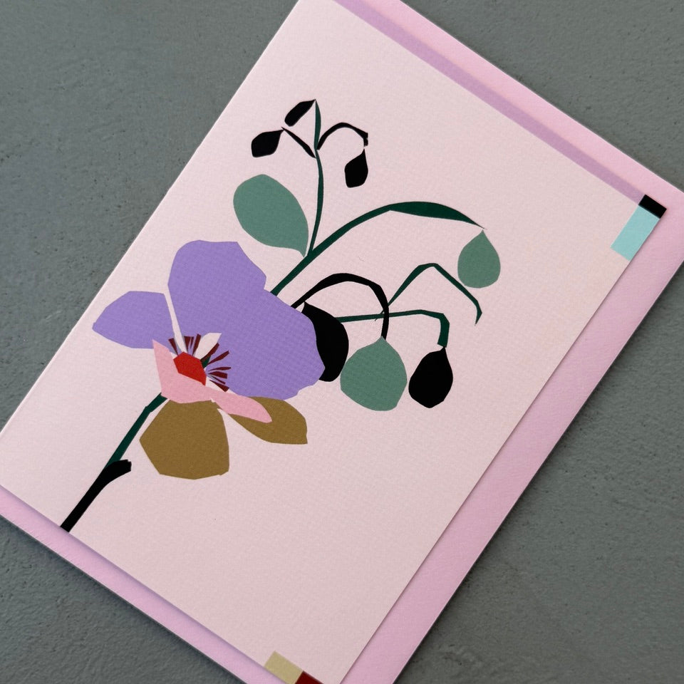 Angled view of the Soft Bloom greeting card on a pink envelope.
