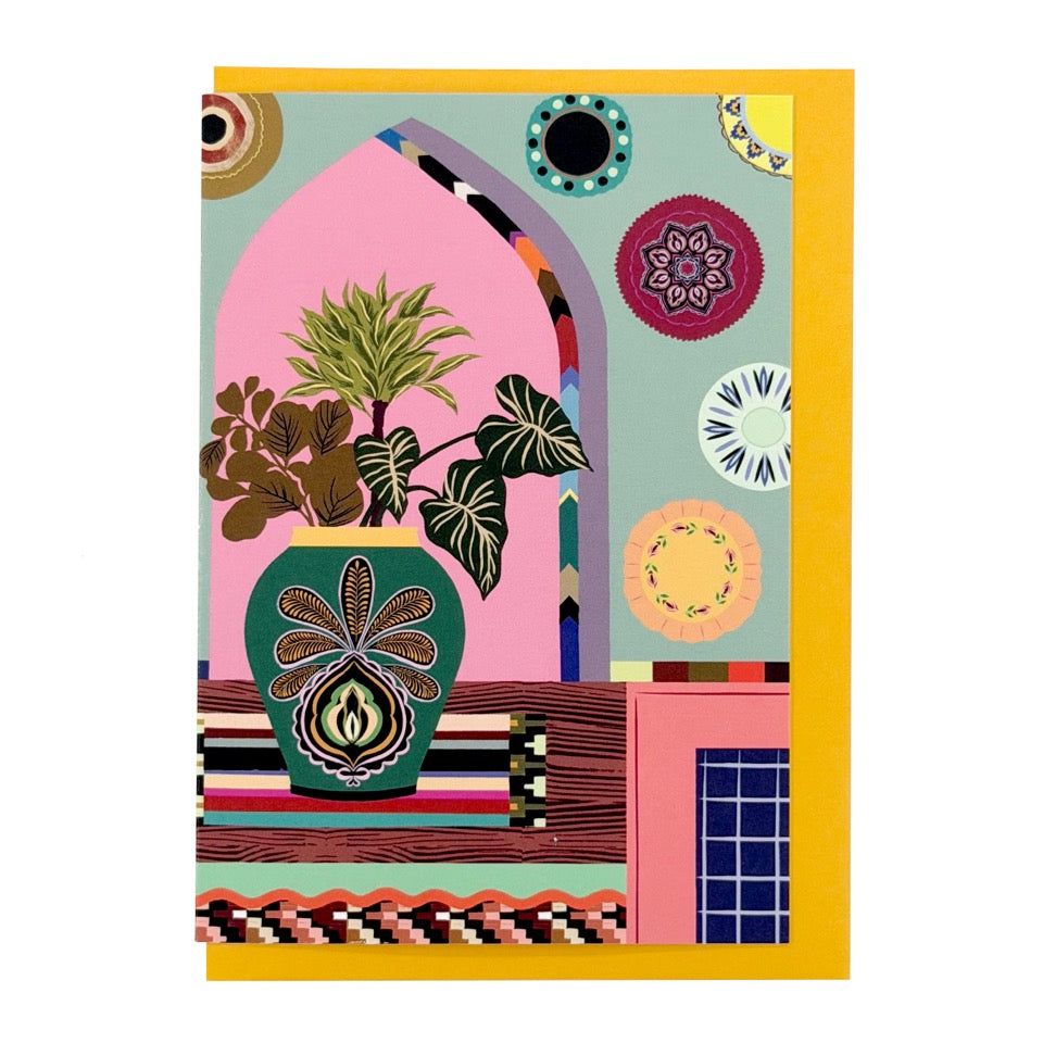 Greeting card featuring an illustrated styled interior with houseplants, decorative ceramics and patterned details on a mustard envelope.
