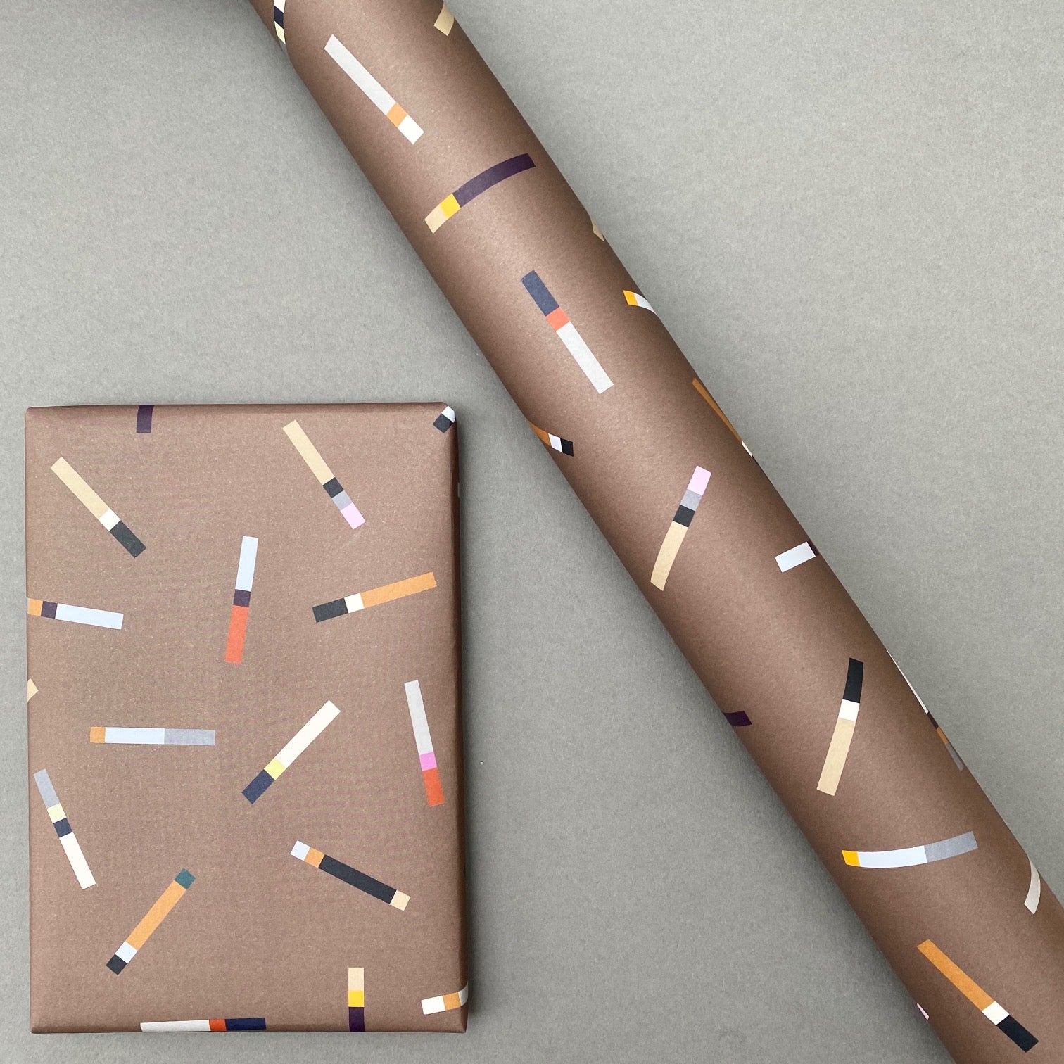 Tab wrapping paper shown as a wrapped gift alongside a roll of the design