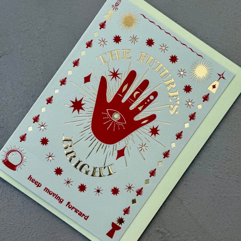 Angled view of the The Future's Bright greeting card with a pale mint envelope, showcasing the symbolic artwork and shimmering foil details.