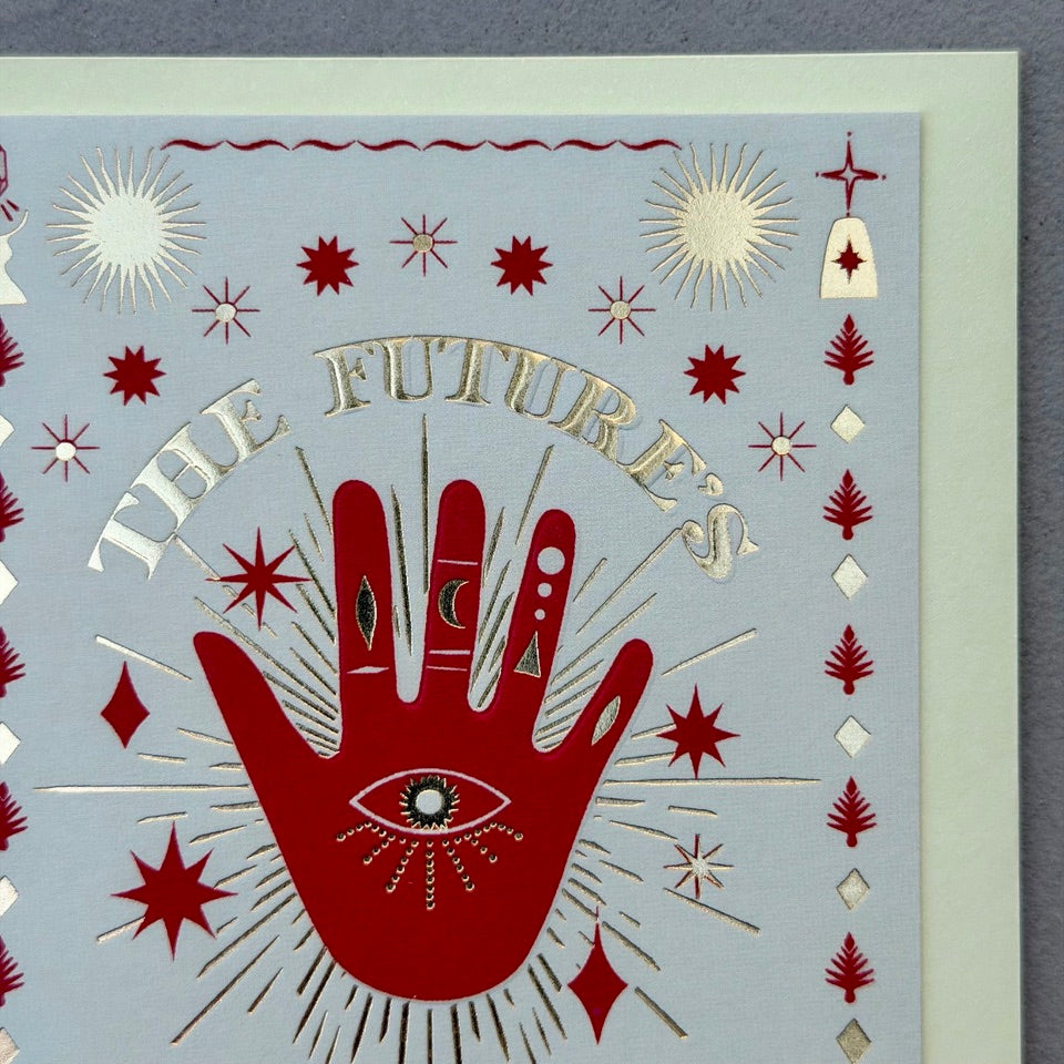 Close-up of the The Future's Bright design highlighting the red hand, metallic gold foil lettering and celestial-inspired illustrations.
