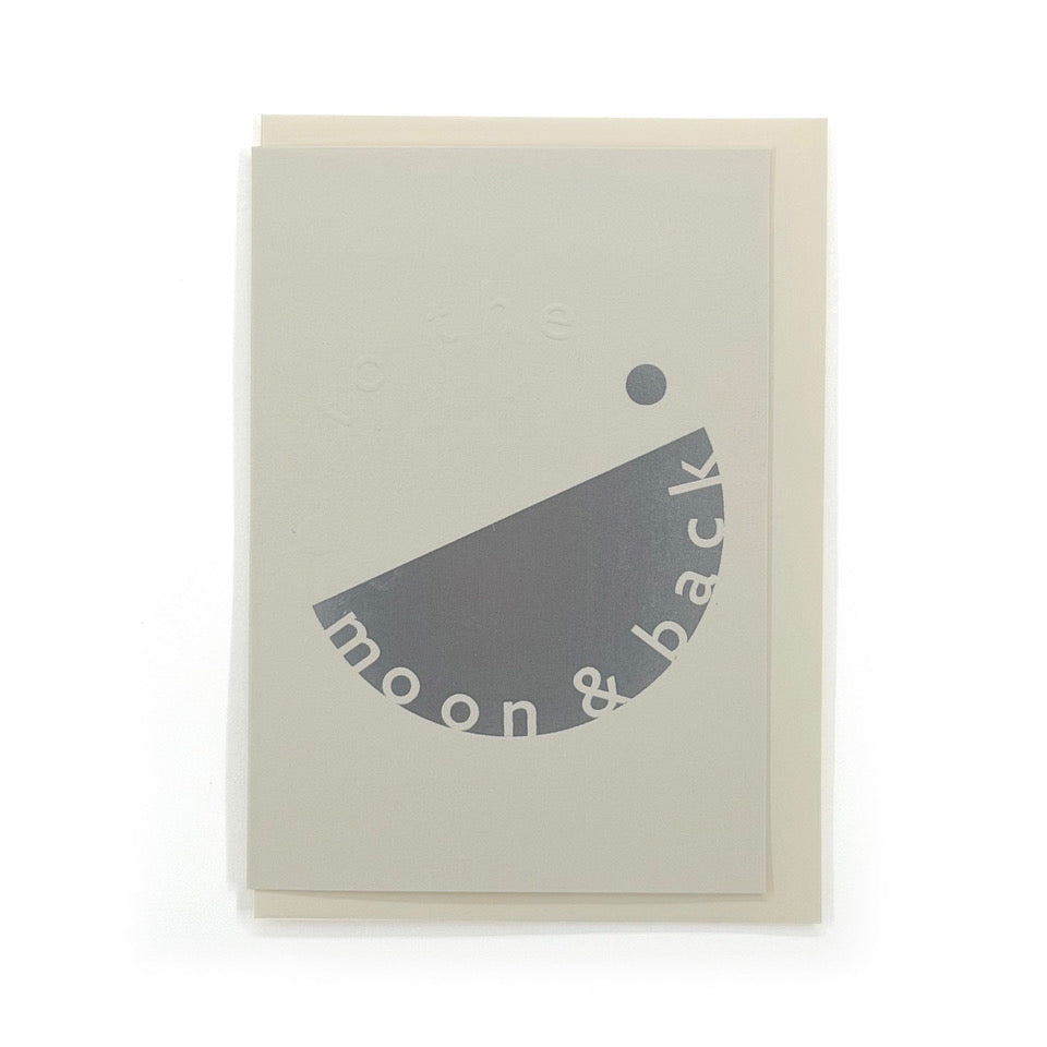 Pale grey To the Moon & Back card with embossed lettering and silver foil graphic, shown with a cream envelope.