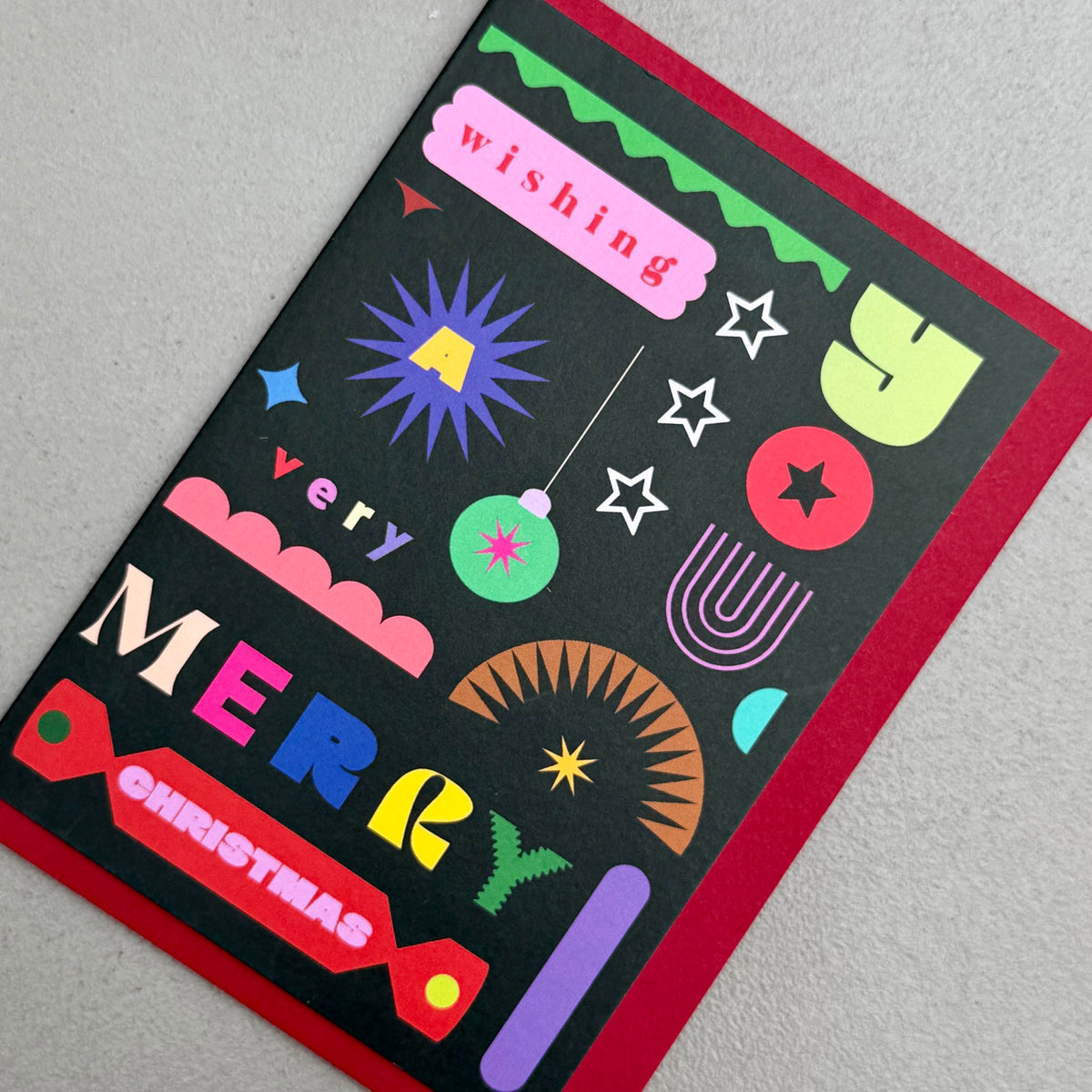 Angled view of Wishing You A Very Merry Christmas card by PAVILION with red envelope
