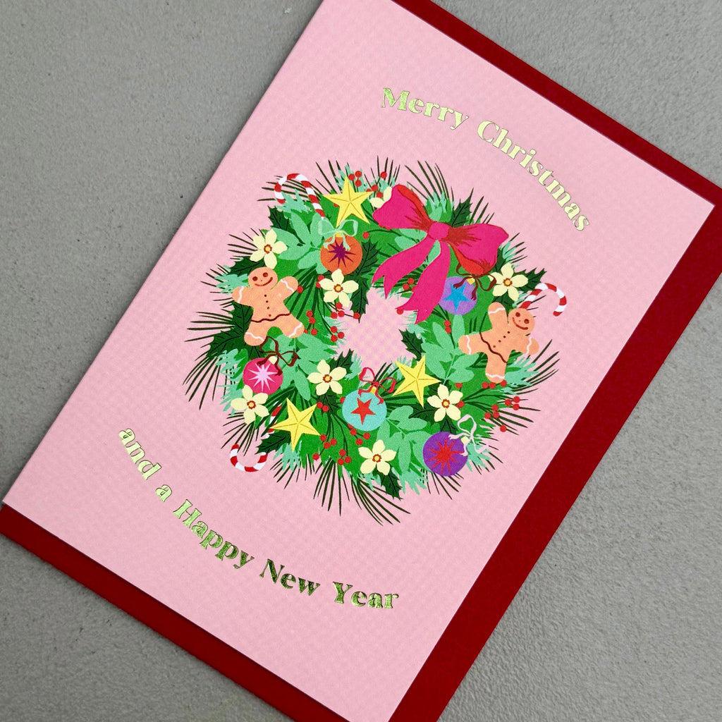 Angled view of Wreath Christmas card by PAVILION with colourful Christmas wreath and red envelope
