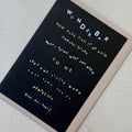 Angled view of the Wunderbar Typography greeting card with a mink envelope, showcasing the contemporary typographic layout and gold foil details.