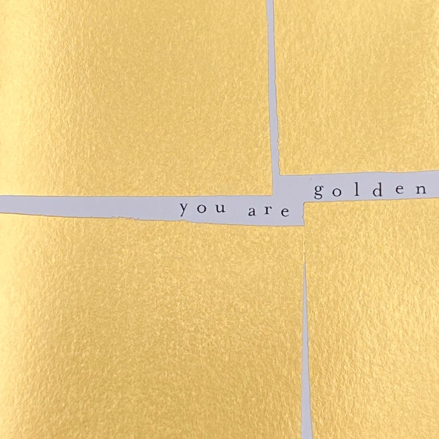 Close-up of the gold foil texture and You Are Golden lettering
